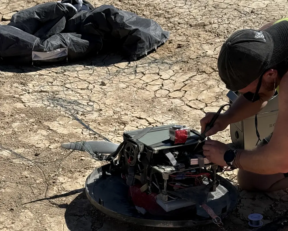 An engineer working on the pod on the lakebed